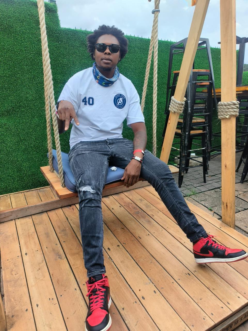 Alpha Team member in a number 40 club shirt seated on a swing