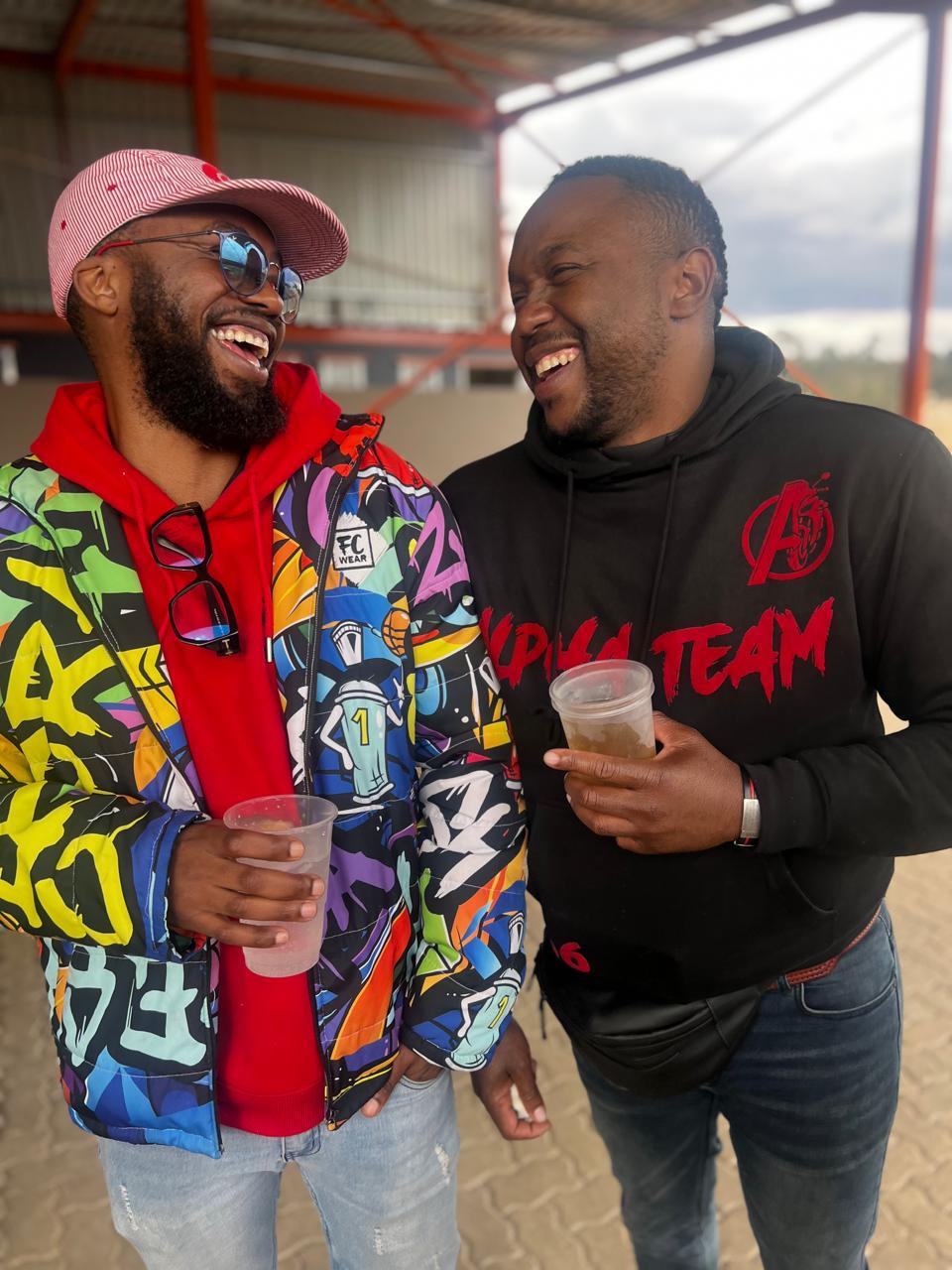 Two Alpha Team members laughing in club hoodies