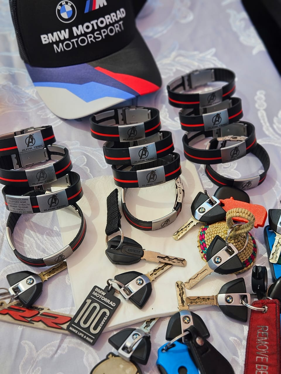 Collection of Alpha Team ICE wristbands and BMW keys laid out together